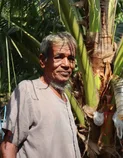 Portrait of Uncle Kanchit holding coconut palm fronds