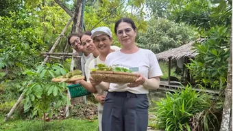 Baan OuadChum staff holding freshly picked garden vegetables