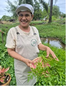 Staff member holding freshly picked herbs from the garden