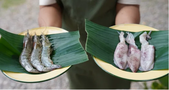 Fresh shrimp and squid on banana leaf plates